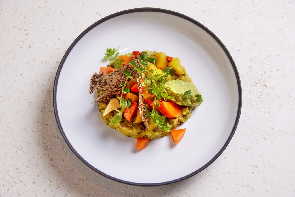 Kitchari, eine ayurvedische Mahlzeit mit Quinoa und Knäckebrot, Karotten und Petersilie